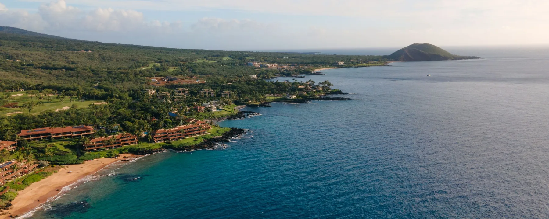 Luftfoto af den grønne Wailea- og Makena-kystlinje på Maui med klippefyldte odder og klart blåt vand